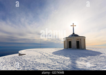 Cristian traverser une petite église avec soleil en contre-jour. Panorama d'hiver italien Banque D'Images