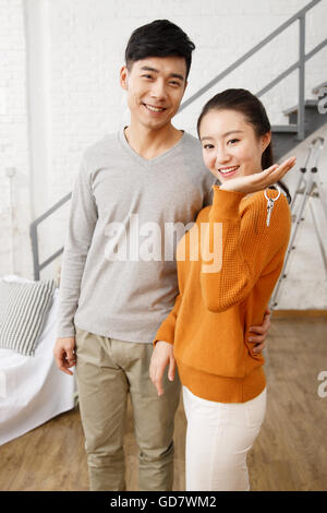 Le happy young couple holding la clé de la chambre Banque D'Images