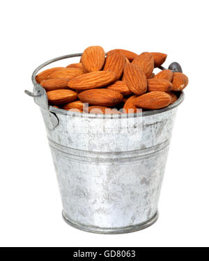 Ancien seau en étain avec des amandes. Isolé sur fond blanc. Banque D'Images