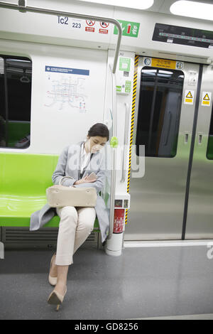 Assez de jeunes femmes pour se reposer dans le métro Banque D'Images