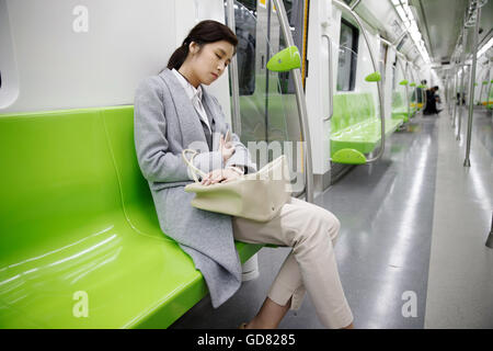 Assez de jeunes femmes pour se reposer dans le métro Banque D'Images