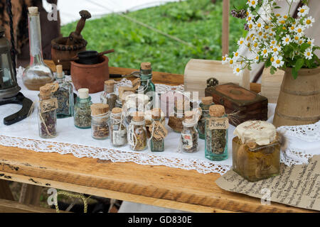 L'herboriste table avec bouteilles d'herbes fraîches à lors de la fête médiévale 2016 Tewkesbury, Gloucestershire, Angleterre. Banque D'Images