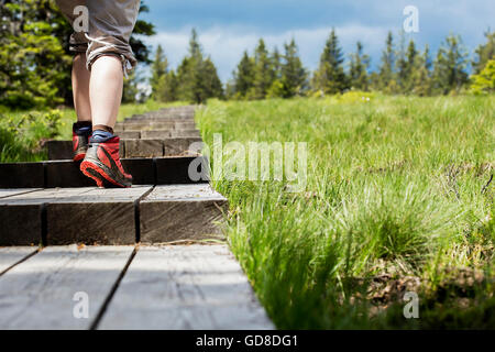Femme marche sur un chemin en bois. Banque D'Images