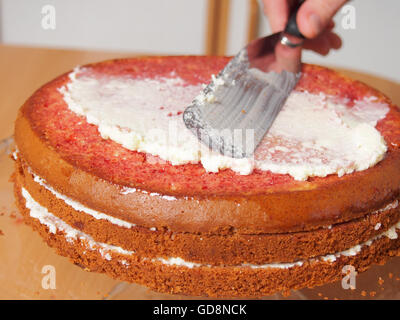 La diffusion de plus de glaçage haut de gâteau. Faire avec remplissage et buttercream Torte au chocolat râpé Garniture. Série. Banque D'Images