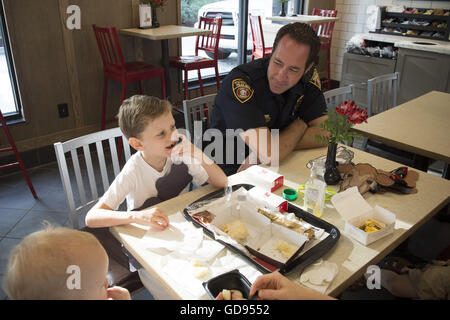 Atlanta, GA, USA. 12 juillet, 2016. Agent de la police locale s'entretient avec les jeunes à un client ''café avec un cop'' matin à Poussin-fil-Un restaurant sur la Journée de reconnaissance de la vache. © Robin Rayne Nelson/ZUMA/Alamy Fil Live News Banque D'Images