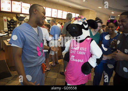 Duluth, GA, USA. 12 juillet, 2016. Molly, une petite vache CFA, flirte avec Jared Taylor, un chercheur biomédical, qui ont attaqué des taches de vache rose à son scrubs medical en célébration de la Journée de reconnaissance de la vache © Robin Rayne Nelson/ZUMA/Alamy Fil Live News Banque D'Images