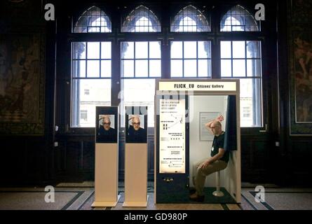 Assistant Galerie Derek Hauffen utilise une photo booth qui fait partie de l'Union FLICK installation interactive qui prend des photos de les visiteurs à l'entrée de l'exposition auxquels le monde : autoportrait de Rembrandt Al Weiwei au Scottish National Portrait Gallery d'Edimbourg. Banque D'Images