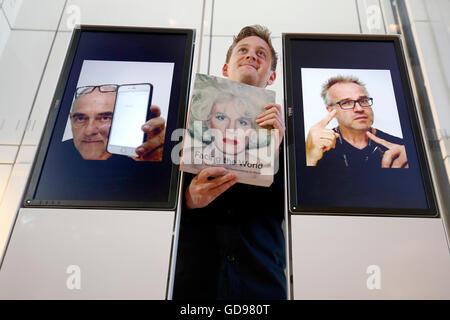 Assistant Galerie Saumure Harris se tient à côté d'un Photo Booth qui fait partie de l'Union FLICK installation interactive qui prend des photos de les visiteurs à l'entrée de l'exposition auxquels le monde : autoportrait de Rembrandt Al Weiwei au Scottish National Portrait Gallery d'Edimbourg. Banque D'Images