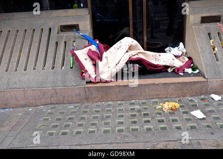 Un sans-abri couverture et déchets sur la chaussée à Londres. Banque D'Images