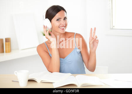 Jeune femme en blouse bleue listening to music on headphones à piscine Banque D'Images