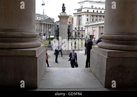 Londres, Royaume-Uni. Un homme sur le point d'entrer dans l'ancien bâtiment de la Bourse de Londres dans le quartier central London war memorial visible Banque D'Images