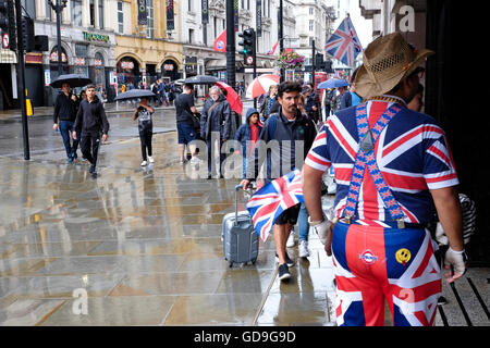 Piccadilly Circus Londres. Un homme vêtu de l'Union Jack encourage les gens à aller dans un magasin sur Piccadilly Circus Banque D'Images