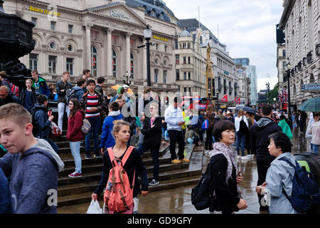 London Piccadilly Circus. Les touristes, debout sur le perron de l'éros dans Piccadilly Circus London sur un jour de pluie Banque D'Images