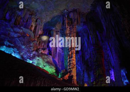 Éclairage éclairage multicolore stalactites, stalagmites et des formations de roche calcaire dans le karstics Reed Flute Cave. Banque D'Images