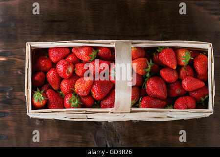 Jus frais mûrs fraises en bois panier carré en bois foncé sur arrière-plan. Vue d'en haut Banque D'Images