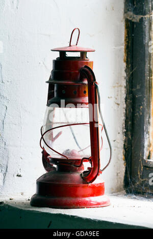 Lampe à huile ancienne assise sur un rebord de fenêtre Banque D'Images