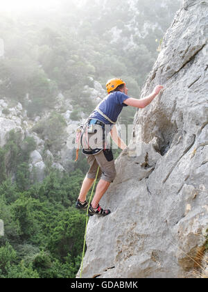 Italie, Sardaigne, grimpeur mur de roche calcaire raide Banque D'Images