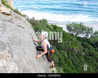 Italie, Sardaigne, grimpeur sur une paroi de rochers sur la mer Banque D'Images