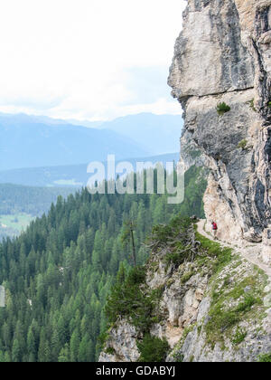 L'Italie, Trentin-Haut-Adige, Provincia di Bolzano, descente de l'Herrsteingipfel, randonneur sur sentier étroit en face de falaise wall Banque D'Images