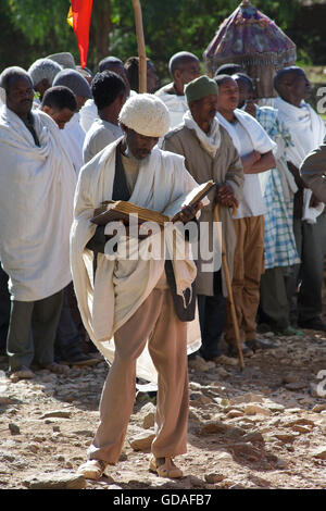 Prêtre éthiopien assistant à un enterrement dans leurs robes liturgiques. La lecture de la bible. Axum, Tigray, Éthiopie Banque D'Images