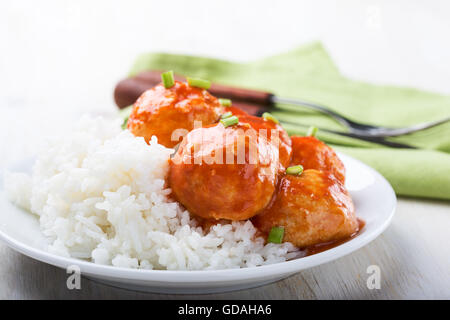 Des boulettes de poulet servi avec du riz sur la table en bois blanc Banque D'Images