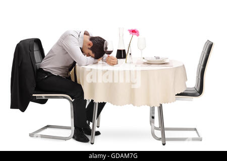 Ivre et Lonely Guy assis à une table de restaurant avec la tête vers le bas, isolé sur fond blanc Banque D'Images