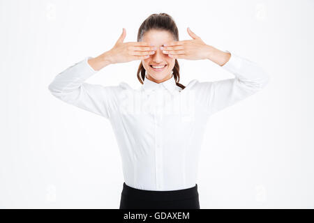 Smiling businesswoman couvrant ses yeux avec les mains sur fond blanc Banque D'Images