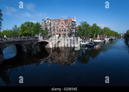 Crooked maisons, bateaux et cyclistes dans la région du canal d'Amsterdam Banque D'Images