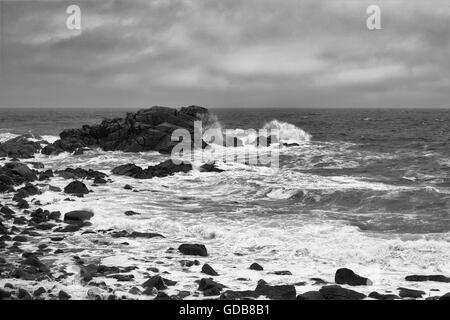 Briser les vagues dans l'épave de Porth, St Mary's, Îles Scilly, au Royaume-Uni. Version noir et blanc Banque D'Images