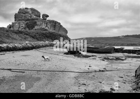 Bateau abandonné par une jetée et Dick's Carn (aka le chameau chargé), Porth Hellick, Saint Mary's, à l'île de Scilly, au Royaume-Uni. Version noir et blanc Banque D'Images