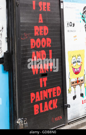 Je vois une porte rouge et je veux qu'il peint en noir - lyrics de hit des Rolling Stones Paint It Black - sur la porte à Londres Banque D'Images