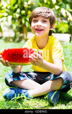 1 Indian Kid boy park Eating Watermelon fruits Banque D'Images