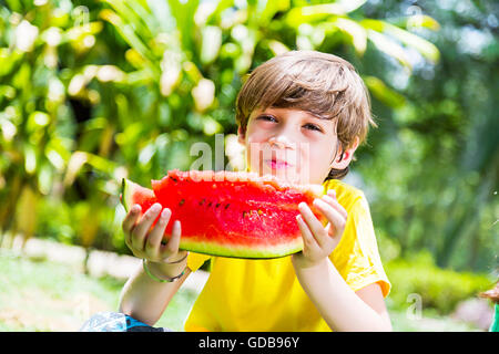 1 Indian Kid boy park Eating Watermelon fruits Banque D'Images