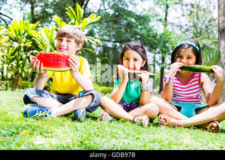 Les enfants indiens 3 amis park Eating Watermelon fruits Banque D'Images