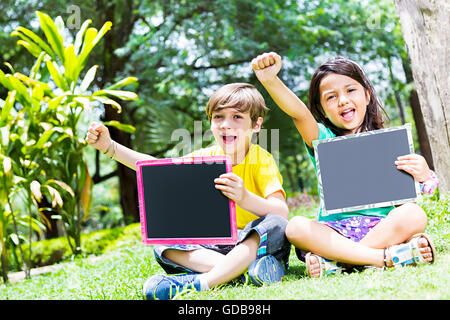 2 enfants fille et garçon indien étudiants amis d'Ardoise parc montrant Banque D'Images