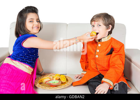 Les enfants indiens 2 frère et sœur Raksha Bandhan Laddu Alimentation Festival Banque D'Images