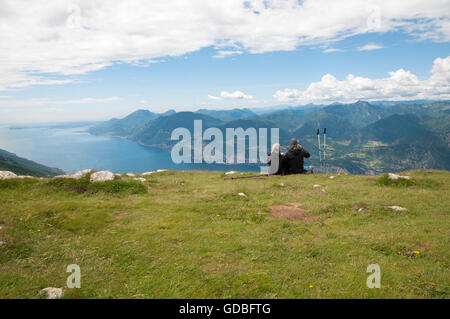 Deux personnes assis sur le dessus de l'Italie du Nord, MonteBaldo et regarder Lago di Garda Banque D'Images