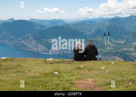 Deux personnes assis sur le dessus de l'Italie du Nord, MonteBaldo et regarder Lago di Garda Banque D'Images