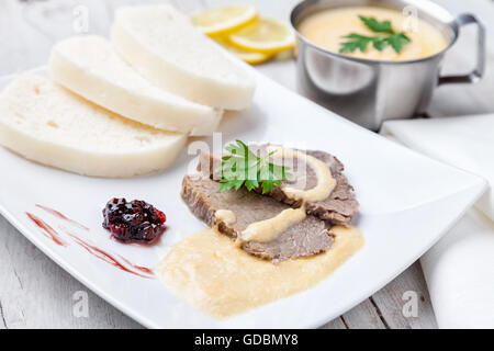 Traditionnel tchèque et slovaque, l'aloyau, sauce crème et de raviolis sur fond de bois Banque D'Images