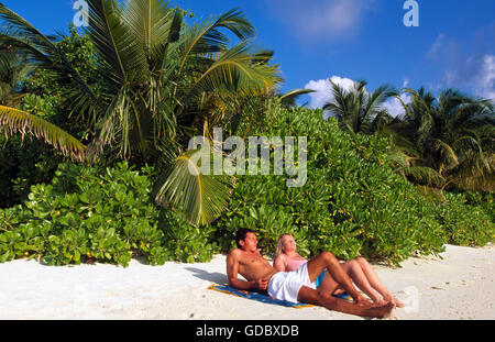 Couple de détente sur la plage, l'île de Baros Maldives, Banque D'Images