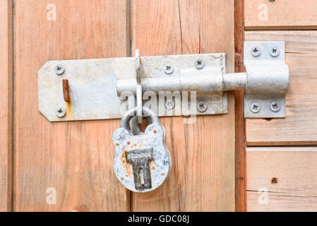 La vis robuste et d'un cadenas sur une porte de l'habitacle en bois Banque D'Images