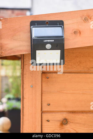 LED à détection de mouvements de la lumière de sécurité fixé sur le côté d'un abri de jardin Banque D'Images