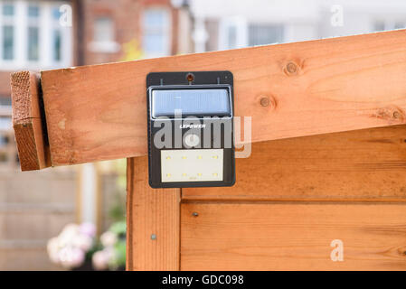 Led à détection de mouvements de la lumière de sécurité fixé sur le côté d'un abri de jardin Banque D'Images