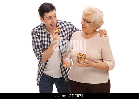 Senior lady en donnant des biscuits à un jeune homme isolé sur fond blanc Banque D'Images