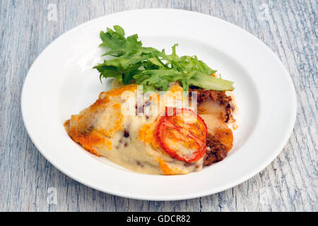 La moussaka d'agneau dans un plat servi à l'extérieur sur la table de pique-nique. Banque D'Images