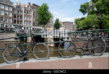 Des vélos sur un pont sur un canal Amsterdam Pays-Bas Banque D'Images