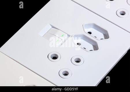 Close up de beige et blanc polyvalents pour les prises et interrupteurs muraux sur noir Banque D'Images