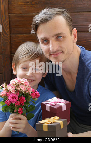 Mari et son fils présenté à la maman fleurs et cadeaux Banque D'Images