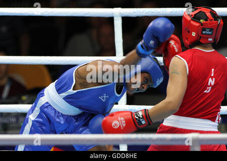 Laishram Devi de l'Inde (rouge) est en concurrence avec Maria Machongua du Mozambique (bleu) dans la demi-finale femmes boxe poids léger (57-60kg) à concurrence des jeux du Commonwealth de 2014 à Glasgow. Laishram Devi de l'Inde est allé sur gagner le combat. Banque D'Images
