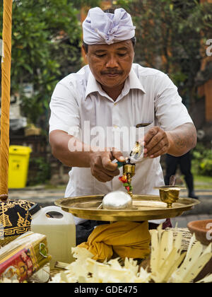 Ubud, Bali, Indonésie. 16 juillet, 2016. Un prêtre hindou prépare un alter avant la crémation de masse à Ubud samedi. La population locale à Ubud exhumé les restes de membres de la famille et brûlé leurs reste dans une cérémonie de crémation de masse mercredi. Près de 100 personnes ont été incinéré et reposent dans la plus grande masse la crémation à Bali en ans cette semaine. La plupart des gens sur Bali sont hindous. Crémations traditionnels de Bali sont très coûteux, afin que les collectivités habituellement une crémation de masse environ tous les cinq ans. (Crédit Banque D'Images